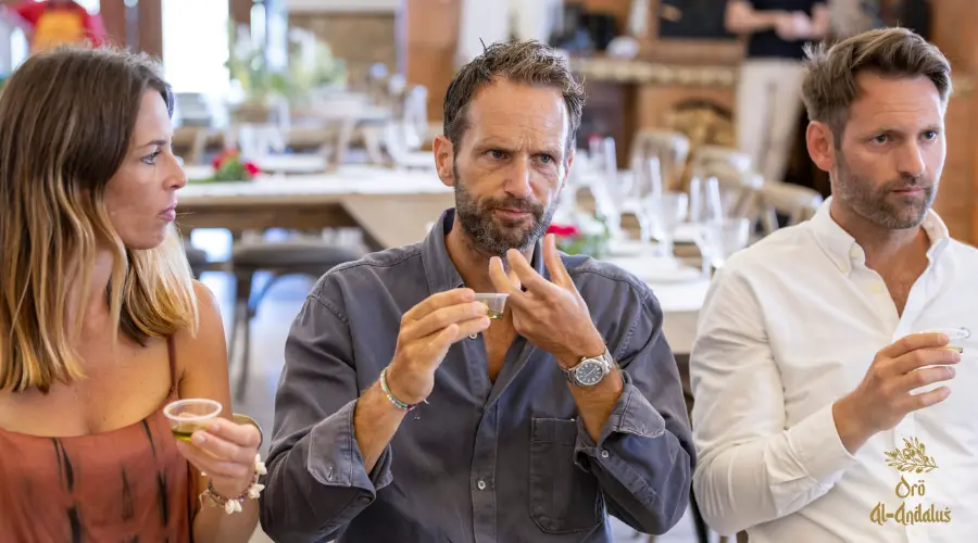 Tres personas realizando una cata de aceite de oliva de Finca Oro Al-Andalus, aprendiendo a identificar un buen AOVE y cuánto aceite de oliva consumir al día.